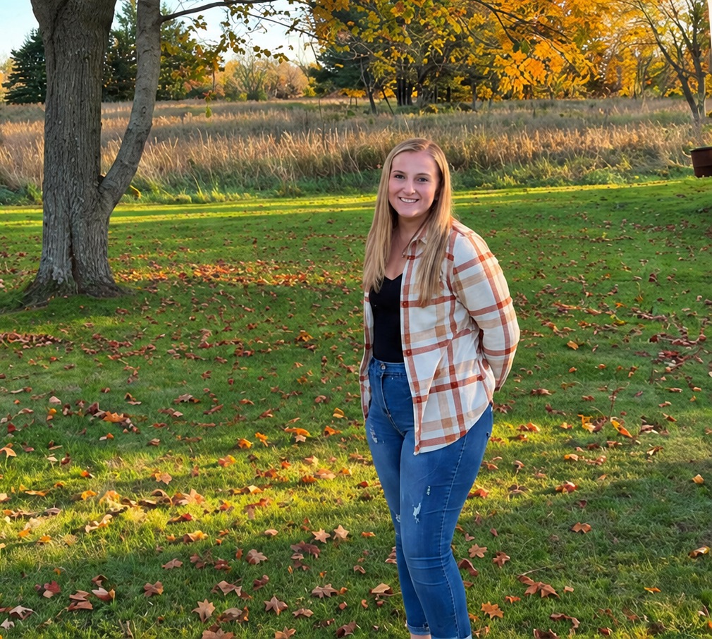 Paula, owner of Beachside Tidy Co., smiling in a sunny autumn yard